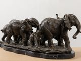 statue of a herd of elephants standing on top of a wooden table