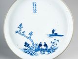 a blue and white plate with a picture of a man on a boat