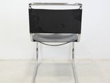 a black and white chair in a room with a white wall