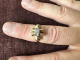 a woman ' s hand with a diamond ring on it