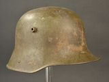 an old military helmet on a metal stand against a gray background