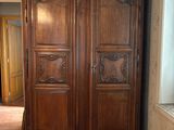 a large wooden armoire in the corner of a room