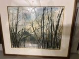 painting of trees in a frame on a shelf in a room