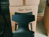 une chaise noire posée devant une pile de cartons
