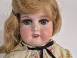 a close up of a doll with blonde hair and blue eyes
