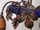 a picture of a blue vase with a bunch of grapes hanging from it