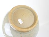a brown vase with a tag on it sitting on a table
