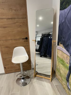 une chaise et un miroir dans une pièce où est accrochée au mur une image représentant un cheval