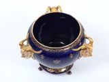 a blue vase with gold decoration on it on a white surface