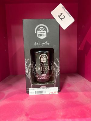 une bouteille de whisky vide repose dans une boîte posée sur une surface rose