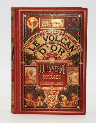 un livre rouge avec des lettres dorées posé sur une surface blanche