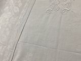 un gros plan sur une nappe blanche ornée d'un monogramme
