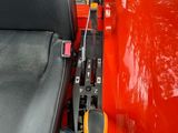a red vehicle with a black seat and a yellow handlebar