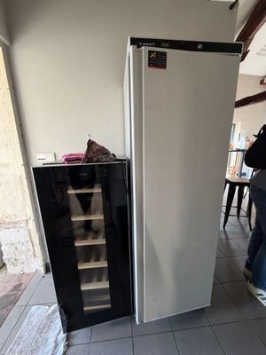 un homme debout à côté d'un réfrigérateur dans une cuisine