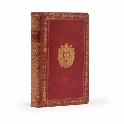 un vieux livre rouge avec un emblème doré sur la couverture