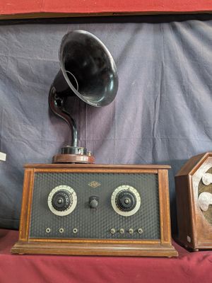 two old fashioned radio ' s on a table with a red cloth