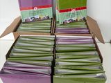 boxes of green and purple cards stacked on top of each other on a table