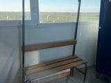 a wooden bench on a balcony with a view of the ocean