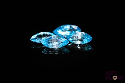un ensemble de trois pierres précieuses de topaze bleue sur fond noir