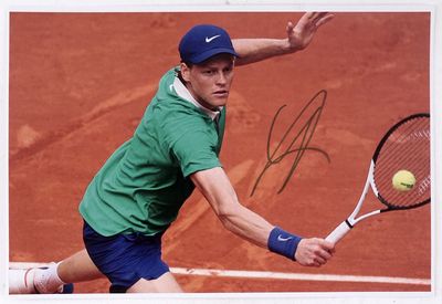signed photo of a tennis player hitting a tennis ball with a racquet