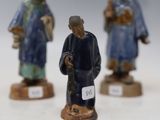 three figurines of a man and a woman on a white surface