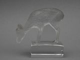 un animal en verre posé sur un socle