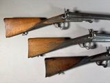 four old guns are lined up on a table
