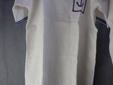 a white shirt that has a blue anchor on it