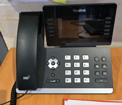 un téléphone posé sur un bureau à côté d'un bloc-notes
