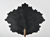 black and white photograph of a candle holder with a black leaf on it