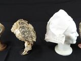 trois types de chapeaux différents et un porte-chapeaux sur fond noir