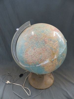 un petit globe terrestre posé sur un socle, sur fond gris