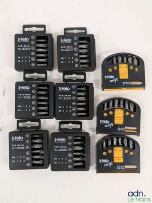 six outils noirs et jaunes sont posés sur une surface blanche