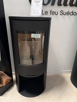 a black stove sitting in front of a wall with a sign above it
