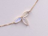 a close up of a gold chain with a white flower on it