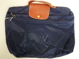 un sac bleu muni d'une poignée marron posé sur une table blanche