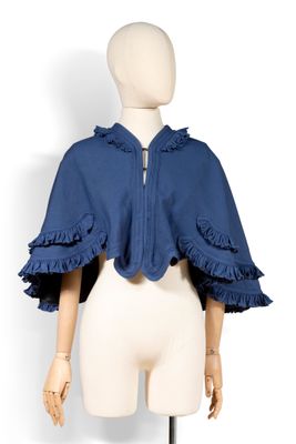 le dos d'un mannequin portant une veste bleue à volants
