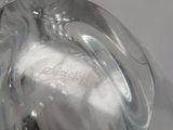 a glass figurine of a bird sitting on top of a table