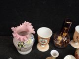 a lot of different vases and cups on the table
