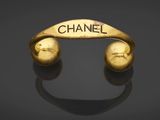 a gold bracelet with the word chanel on it