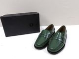 a pair of green shoes sitting next to a black box