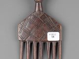 a small wooden comb with a decorative design on it