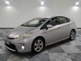 une photo d'une Toyota Prius argentée garée sur un sol à damier