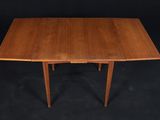 a walnut dining table with two leaves on the top