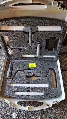 une mallette posée par terre, contenant des outils
