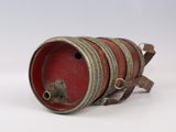 a red barrel with a metal handle on a white surface