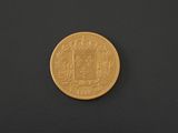 a gold coin on a black surface