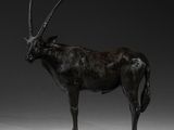 statue d'une antilope debout sur une surface blanche, sur fond noir