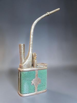 a green and gold cigarette case with a pipe sticking out of it