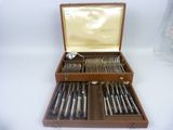 a wooden case with silverware in it on a white surface